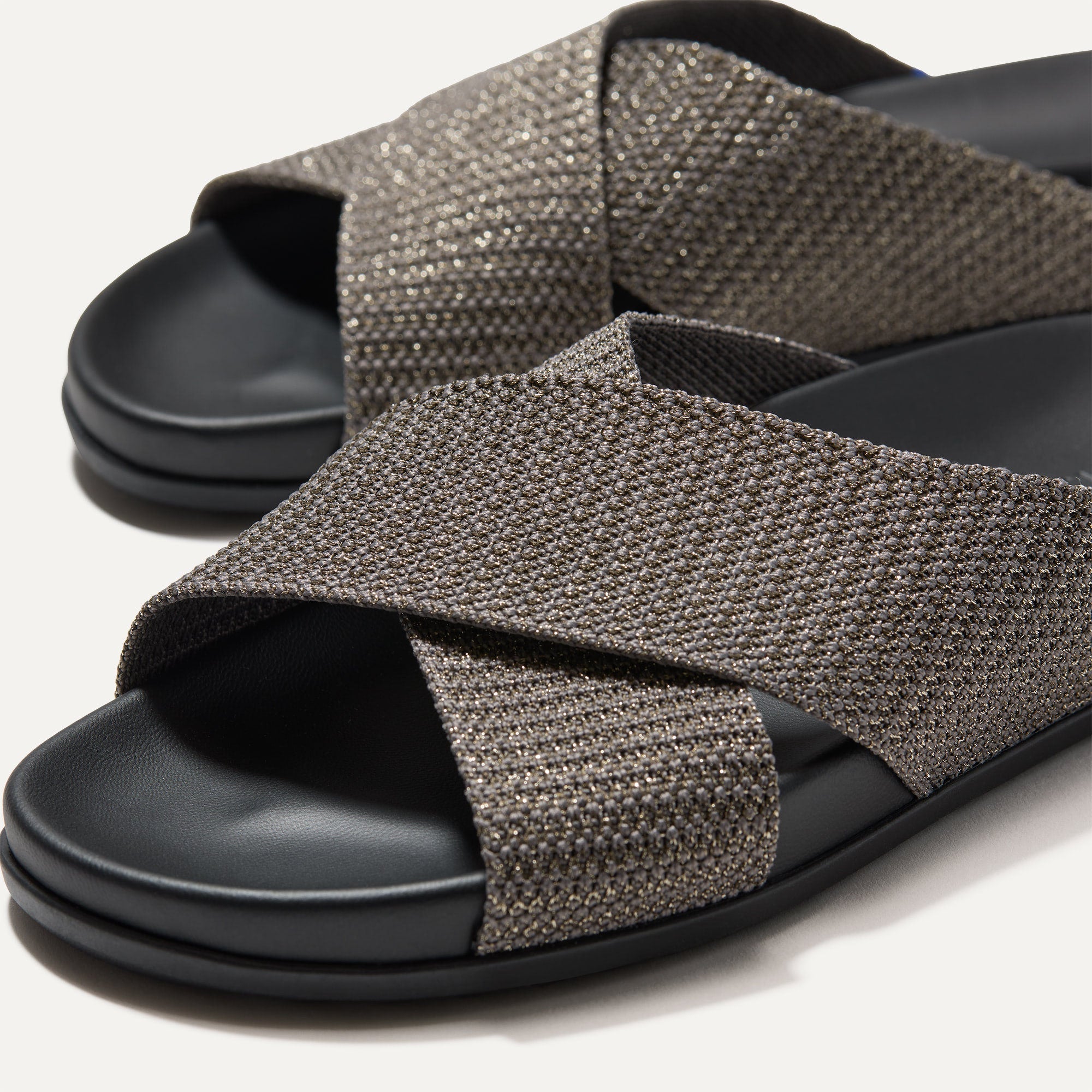 Close up of the crossing knit straps and toe of The Weekend Slide in Silver Sand, shown in diagonal view. 