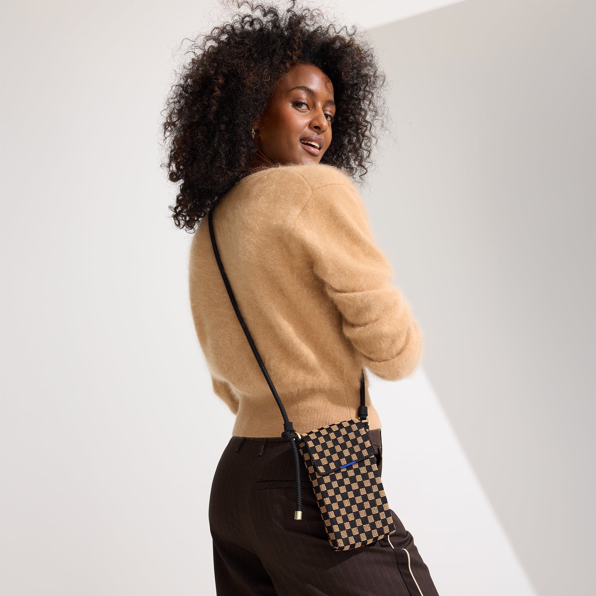 An alternate view of a model wearing The Phone Crossbody in Midnight Song.
