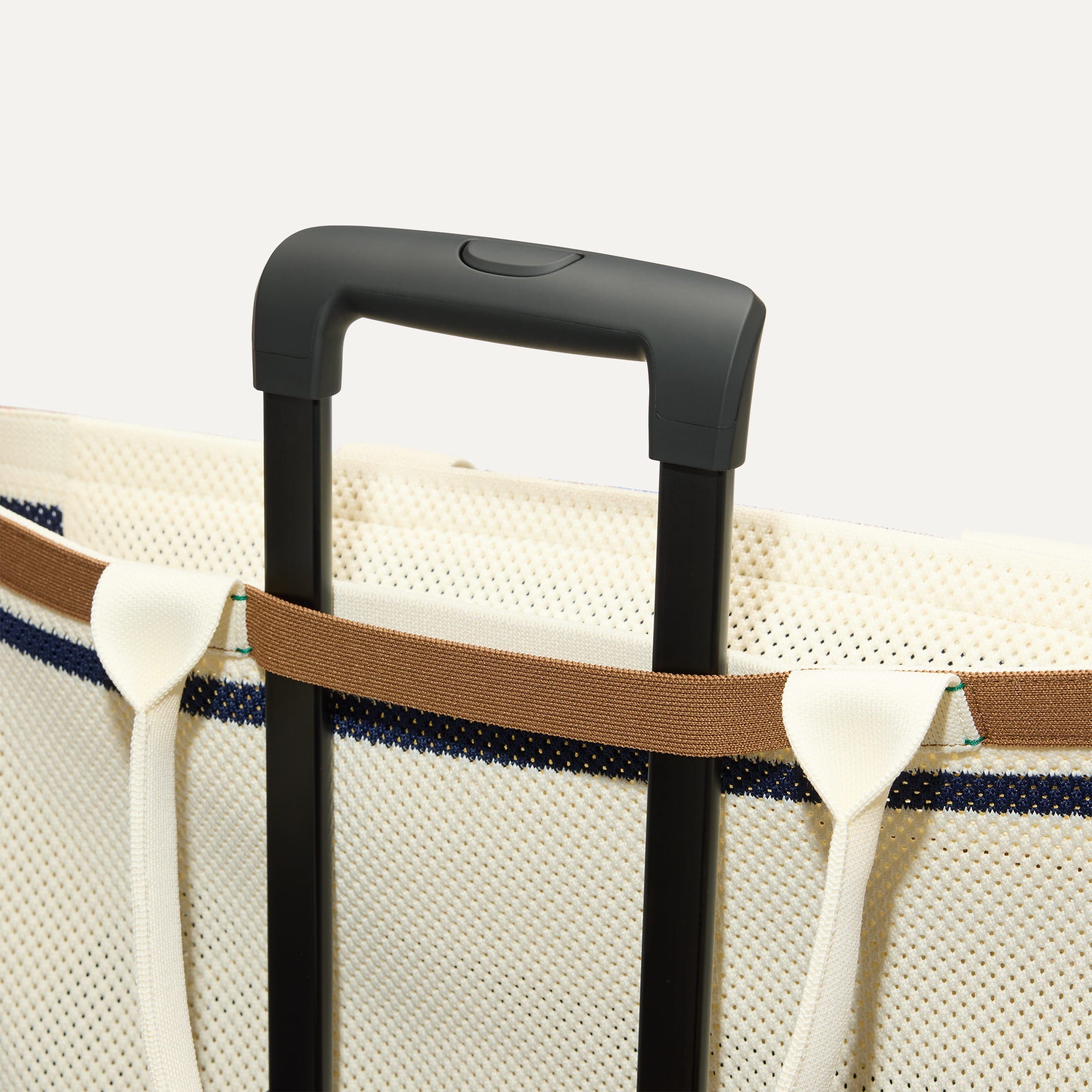 The Zip Travel Tote shown attached to a rolling suitcase using the wrap-around band.